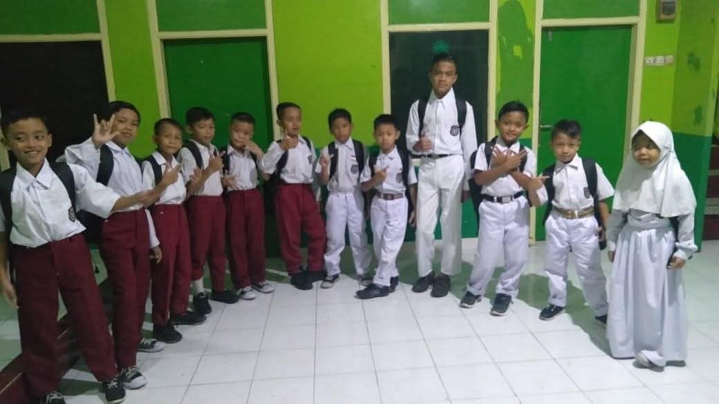 Anak-anak mengenakan seragam sekolah dasar