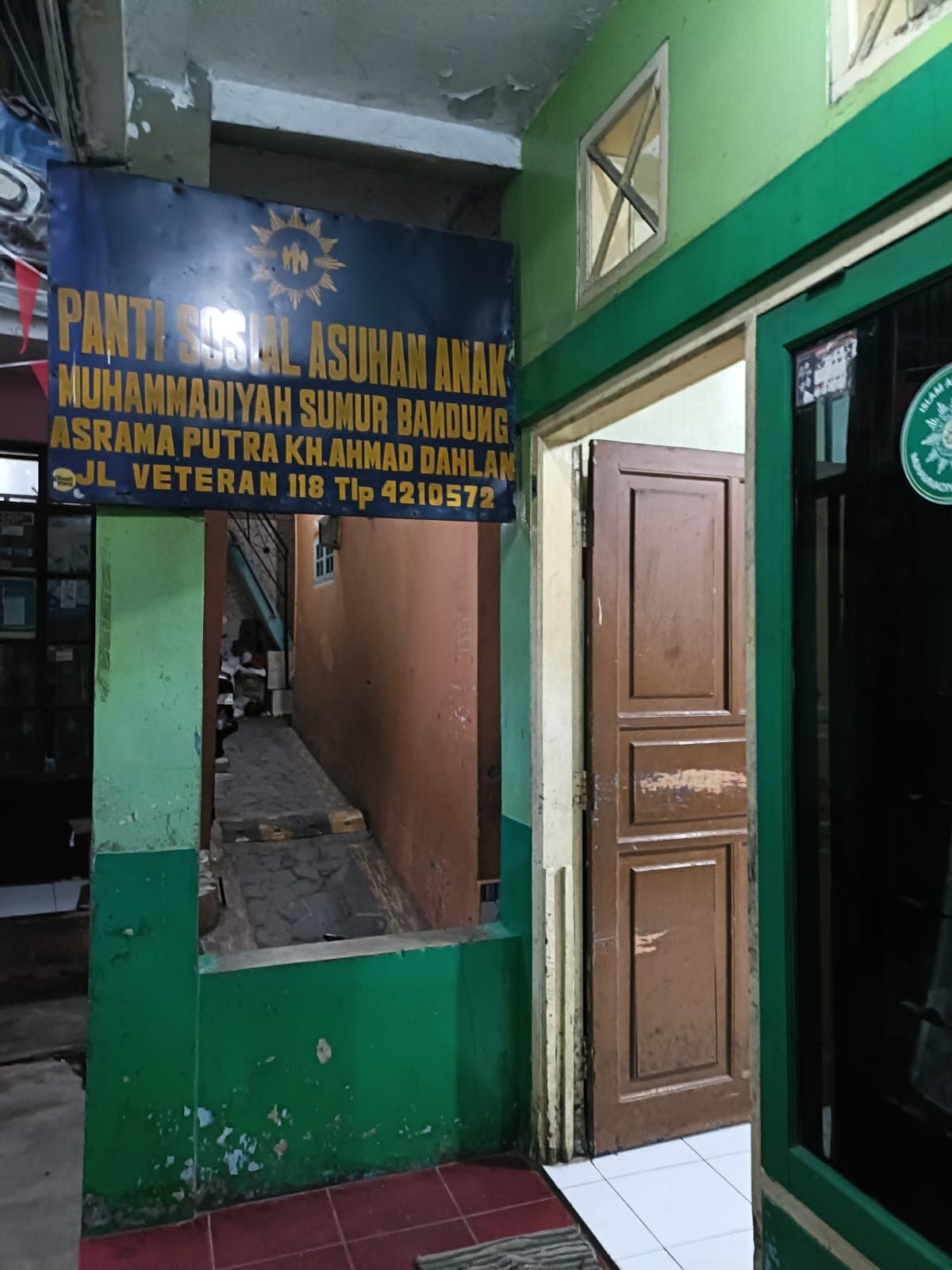 Pintu masuk dan papan nama asrama putra